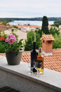 a bottle of wine and two glasses on a ledge at Freya's Apartments Medulin in Medulin