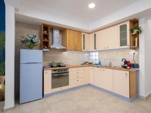 a kitchen with white appliances and wooden cabinets at Blue Siri Apartment in Heraklio