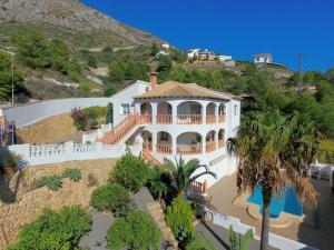 a large white house on top of a hill at Large chalet with private pool in Altea