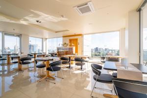 a cafeteria with tables and chairs and large windows at Hotel Mare in Lignano Sabbiadoro