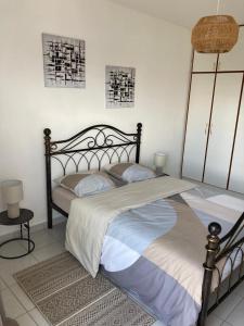 a bedroom with a large bed with two pillows at T2 COSY, LUMINEUX ET SPACIEUX in Cayenne