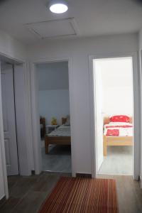 Habitación blanca con cama y habitación con ventana en Holiday Home Smile, en Bihać