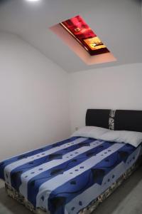 a bed in a bedroom with a painting on the ceiling at Holiday Home Smile in Bihać