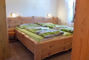 a bedroom with a wooden bed with green sheets at Ranč Podlesok in Hrabušice