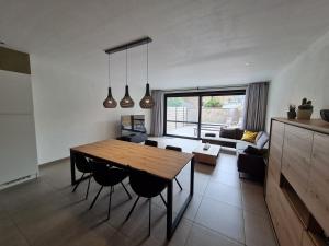 een keuken en een woonkamer met een houten tafel en stoelen bij Vakantiehuis Mariakerke in Oostende