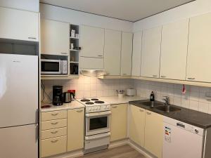a kitchen with white cabinets and a stove top oven at Rovaniemi budget travels in Rovaniemi
