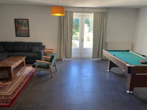 a living room with a pool table and a couch at La Maison du Petit Jacques in Aumagne