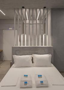 a large white bed with three pillows on it at Viva Mare Studios in Astypalaia Town