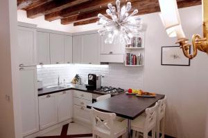 a kitchen with a table and a chandelier at Ca Spada 2 Bedrooms & 2 Bathrooms Venice Apartment in Venice
