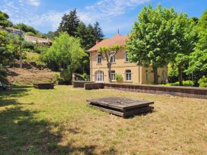 een grote tuin met een huis op de achtergrond bij Villa Benjamine - Parc Haut Languedoc in Lamalou-les-Bains