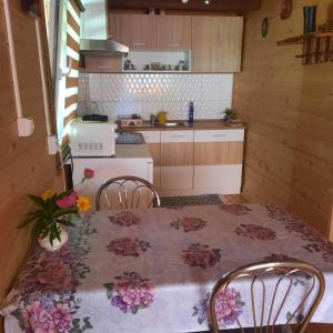 a kitchen with a table and two chairs and a kitchen with a table at U Garnuszka in Krasnopol