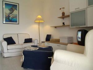 Una sala de estar con dos sillas y un televisor. en Donnafugata Relais, en Marina di Ragusa