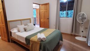 a bedroom with a bed with two towels on it at Colibri Apartments - Private kitchen & bathroom - 4 min walk to the Beach! in Santa Teresa Beach +48 photos