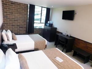 Ένα ή περισσότερα κρεβάτια σε δωμάτιο στο Hotel Acqua Medellín