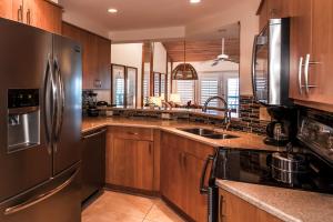 a kitchen with wooden cabinets and a stainless steel refrigerator at Galleon Resort and Marina in Key West