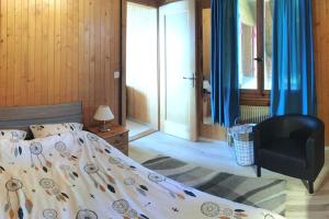 - une chambre avec un lit et une chaise dans l'établissement Chalet Tyl, vue imprenable sur les Alpes Valaisannes, à Crans-Montana