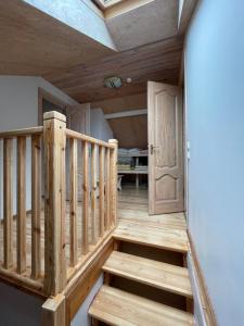 eine Holztreppe in einem Zimmer mit einer Tür in der Unterkunft Pulkvedis Guest House in Ventspils