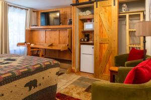 a bedroom with a bed and a desk and a kitchen at Alpen Way Chalet Mountain Lodge in Evergreen