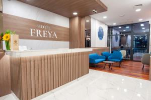 a hotel lobby with a hotel fresaya sign and blue chairs at Hotel Freya in Struga