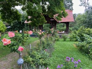 a garden with flowers and a gazebo at Ferienwohnung Sandwirtin in Schwanberg