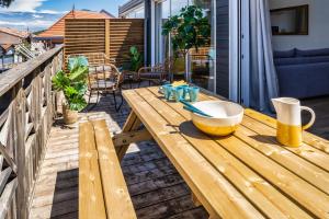 a wooden table on a deck with a bowl on it at MAMITA 2 beautiful spacious and bright apartment T4 74m 18m of terrace in Lacanau-Océan +15 photos