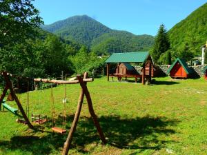 un gruppo di tende in un campo con montagne sullo sfondo di Private accommodation Kalezić a Mojkovac