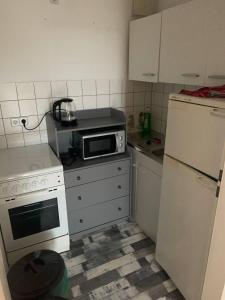 a small kitchen with a microwave and a refrigerator at Apartments K11 für Monteure in Chemnitz in Chemnitz