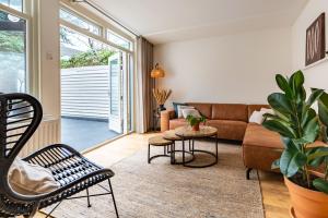 a living room with a couch and a table at Unieke stadswoning met jacuzzi en sauna max 8 pers in Goes