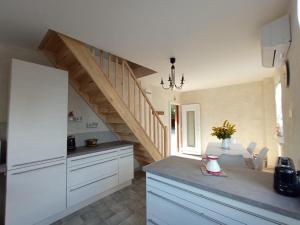 a kitchen with white cabinets and a staircase at Gites les cocottes in Zellwiller