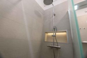 a shower with a shower head in a bathroom at Apartment Silo 22 in Šilo
