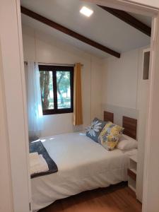 a bedroom with a large bed with a window at Camping Vila de Sarria in Sarria