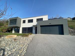 une maison avec un grand garage sur une colline dans l'établissement Villa luxueuse à 10 minutes de Crans-Montana, à Crans-Montana