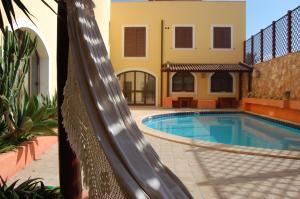 a swimming pool in front of a house at El Mosaico Del Sol in Lampedusa