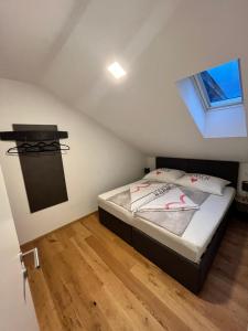 a bedroom with a bed in a attic with a window at Neues Traunsee Apartment Altmünster in Altmünster