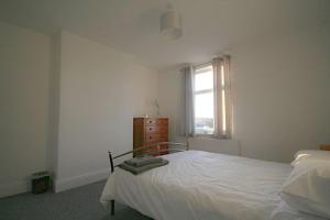 a white bedroom with a bed and a window at Charming 3-Bed House in Whitwell village in Worksop