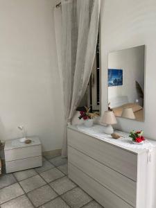 a bedroom with a dresser with a mirror and a bed at Guest House “Nonna Rossa” in Naples