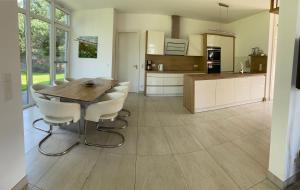 a kitchen with a wooden table and white chairs at 5 Sterne Luxusdomizil im Dünenland in Ostseebad Karlshagen