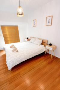 una camera con letto bianco e pavimento in legno di Arcadia - Péniche de Standing à Namur avec vue sur la Citadelle a Namur
