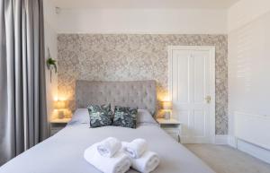 een slaapkamer met een bed met handdoeken erop bij Bootham Apartment 32 - Free Parking - Five minute walk to York Minster in York