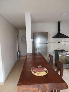 a kitchen with a wooden table and a refrigerator at Casa La Comarca in San Rafael