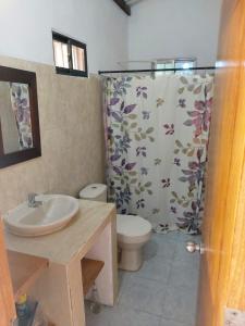 a bathroom with a toilet and a shower curtain at El ensueño in San Bernardo del Viento