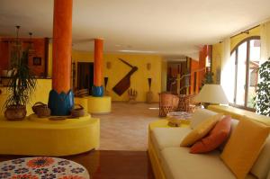 a living room with a yellow couch and a living room with at El Mosaico Del Sol in Lampedusa