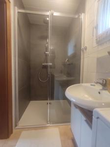 a bathroom with a shower and a sink at Family Home Weißensee in Greifenburg