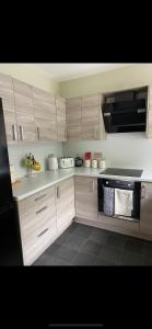 a kitchen with wooden cabinets and a stove top oven at NC500, Wick Caithness Holiday Home in Wick
