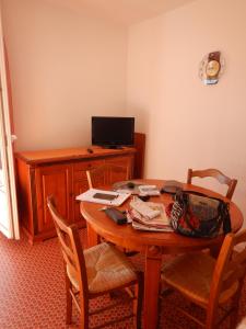 Pokój z drewnianym stołem z krzesłami i telewizorem w obiekcie Appartement 4 personnes - Argelès-sur-Mer w Argelès-sur-Mer