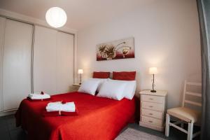 サン・ヴィセンテ・フェレイラにあるCasa das Palmeirasのベッドルーム1室(赤いベッド1台、タオル2枚付)