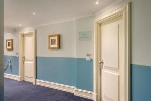 拉帕洛的住宿－Grand Hotel Bristol Spa Resort, by R Collection Hotels，走廊上设有蓝色和白色的墙壁和门