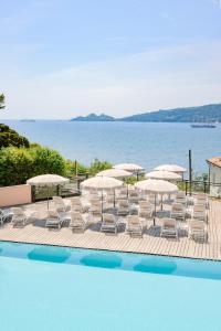 un grupo de sillas y sombrillas junto a una piscina en Grand Hotel Bristol Spa Resort, by R Collection Hotels, en Rapallo