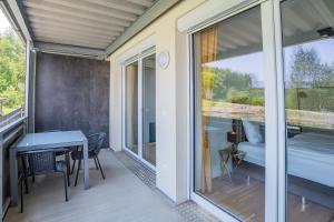 a room with a balcony with a bed and a table at CT-GOLD Apartments - Villach Malina - nahe Atrio und Therme in Villach