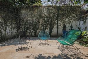 three chairs sitting on a patio next to a wall at Casa Sabina in Guadalajara
